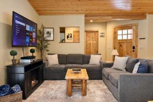 a living room with a couch and a flat screen tv at River Song Cabin home in Leavenworth