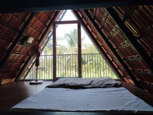 a bed in a room with a large window at Arundekar's Cottage in Gokarna +14 photos