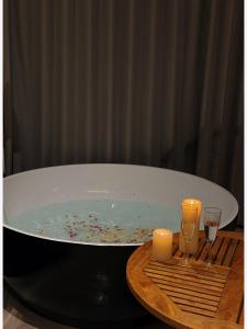a bath tub with two candles and two wine glasses at Dali Yuanlu Hanging Garden Hotel, located in the center of Dali Old City, has rich cultural heritage, convenient travel, butler service, free parking, free breakfast, afternoon tea, coffee, mini bar, and traditional Chinese tea in Dali Ancient Town