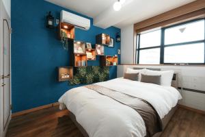 a bedroom with blue walls and a large bed at Prosper 47th bldg in Nagoya