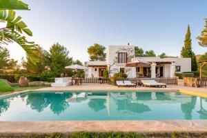 a villa with a swimming pool in front of a house at Sa Vinyeta in Sant Llorenç de Balafia