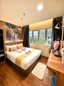 a bedroom with a large bed and a desk at Swiss Hotel Kuala Lumpur in Kuala Lumpur