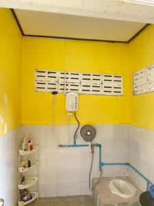 a bathroom with a yellow wall and a sink at Pakse Chill Hostel in Pakse +36 photos