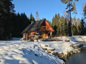 a log cabin in the snow at Ala-Kure metsamaja in Varbuse