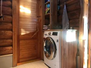 a washer and dryer in a room with wooden walls at Ala-Kure metsamaja in Varbuse