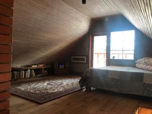 a bedroom with a bed and a large window at Ala-Kure metsamaja in Varbuse