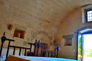 Cette chambre est dotée d'un mur en pierre avec une table et des chaises. dans l'établissement CASINO de VITI - Dimora storica con piscina, à Vaste