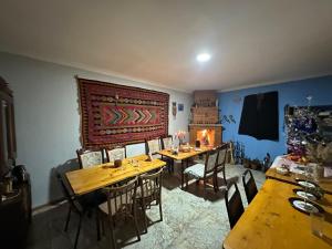 a dining room with two tables and a fireplace at Hotel-GVALA in Vardzia
