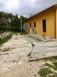 a road leading to a yellow building at Campo della Corte in Castelpagano