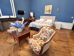 a bedroom with a bed and a chair and a table at Experiencebruges in Bruges