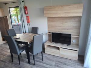 a dining room with a table and a television at Panorama Best View in Lauwersoog