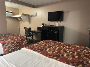 a hotel room with two beds and a desk and a television at Dream Inn in Tonopah