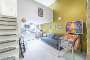 a living room with a blue couch and a pinball at happy home JOY - apartment with free Pinball Machine in Budapest