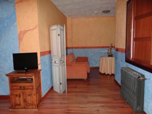 a living room with a television and a couch at La Hacienda de mi Señor in Lerma