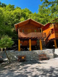 a large wooden cabin with two benches in front of it at Guri i Lekës Guesthouse in Shkodër