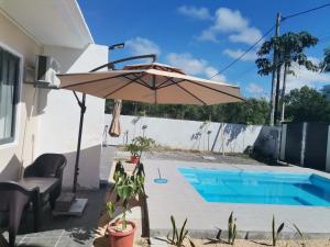 a patio with an umbrella and a swimming pool at Serene Villa in Grand-Baie