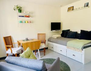ein Schlafzimmer mit Bett und Schreibtisch mit Fernseher in der Unterkunft Studio 32 in Lund