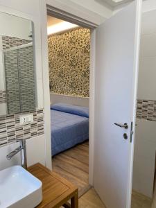 a bathroom with a bed and a sink and a mirror at La Casa Sul Viale in Iesi