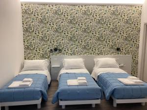 a bedroom with two beds and a wall with a mural at La Casa Sul Viale in Iesi