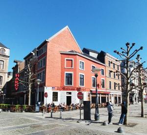 un edificio en una calle de la ciudad con gente de pie fuera en Apart'Hotel Liège City Centre en Lieja