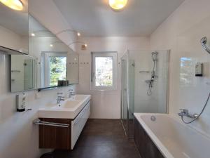 a bathroom with a sink and a tub and a shower at Falcon Lodge Kaprun Kitzsteinhorn - Steinbock Lodges in Kaprun +33 photos