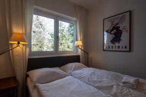 a bedroom with a bed and a window at Falcon Lodge Kaprun Kitzsteinhorn - Steinbock Lodges in Kaprun