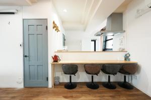 a kitchen with a counter and two stools at Prosper 47th bldg in Nagoya