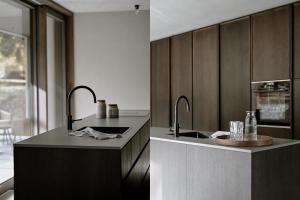 a kitchen with two faucets and a sink at BAUA Gartenhaus in Maurach