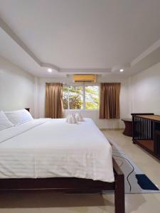 a bedroom with a large white bed and a window at Hello Jomtien in Jomtien Beach +20 photos