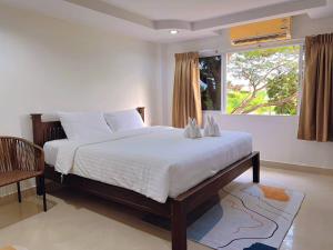 a bedroom with a large bed and a window at Hello Jomtien in Jomtien Beach