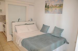 a bedroom with a white bed with a blue blanket at Sunset by the sea 2 in Loutraki