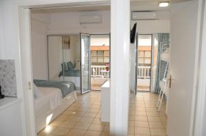 a bedroom with a bed and a balcony at Sunset by the sea 2 in Loutraki