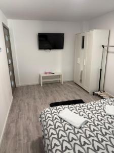 a bedroom with a bed and a tv on a wall at EVEREST 33 Garsoniera in Bucharest