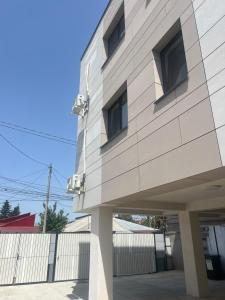 a white building with windows and a fence at EVEREST 33 Garsoniera in Bucharest