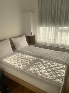 a large bed in a bedroom with a window at Privatni apartman A15 Vučko Aparthotel in Jahorina