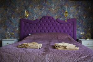 a purple bed with a purple comforter and two nightstanduments at Апартамент за гости Марица in Asenovgrad