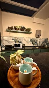a table with two cups and a plate of plants at Chérie Bliss Loft in Jaipur +21 photos