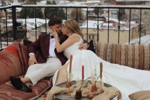 a bride and groom sitting on a couch at Kismet Cave Mansion in Göreme