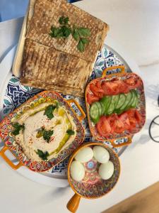 a plate of food with eggs and vegetables on a table at Golan Zimmer - צימר הגולן in Mas'ada