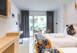 a hotel room with two beds and a table at Sandy Blooms in Ukulhas +40 photos