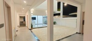 a hallway of a house with white walls and ceilings at Sandy Blooms in Ukulhas