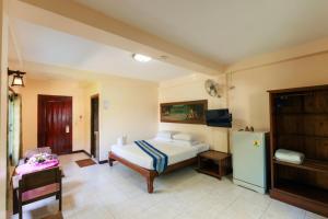 a bedroom with a bed and a refrigerator at SK House 2 in Chiang Mai