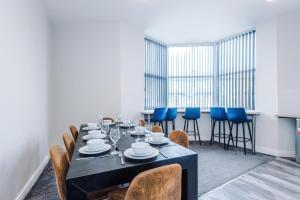 a dining room with a black table and blue chairs at Spacious 6-Bedroom Central Blackpool in Blackpool