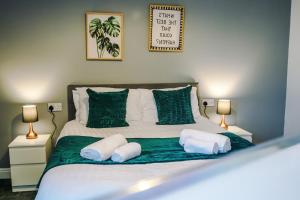 a bedroom with a bed with green and white pillows at Spacious 6-Bedroom Central Blackpool in Blackpool +117 photos