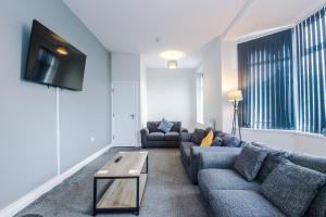 a living room with two couches and a flat screen tv at Spacious 6-Bedroom Central Blackpool in Blackpool