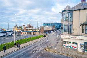 a city street with buildings and people walking on the street at Spacious 6-Bedroom Central Blackpool in Blackpool