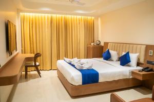 a hotel room with a large bed and a desk at AAA URBAN STAY-Madhapur in Hyderabad +26 photos