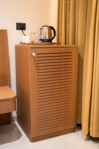 a wooden cabinet with a tea kettle on top of it at AAA URBAN STAY-Madhapur in Hyderabad