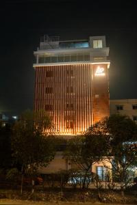 a tall building with lights on it at night at AAA URBAN STAY-Madhapur in Hyderabad