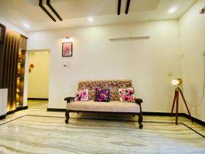 a room with a bench with pillows on it at Sowkya Stays, Kakinada - Home Stay, Service Apartment, Vididhillu in Kākināda
